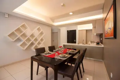 a dining room with a black table and chairs at Suasana Bukit Ceylon by Plush in Kuala Lumpur