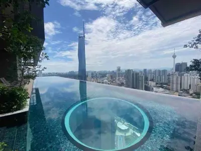 a glass infinity pool with a view of the city at Maxhome at Lucentia Bukit Bintang City centre KL in Kuala Lumpur