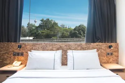 a bedroom with a white bed with a large window at i-Hotel Kuala Lumpur in Kuala Lumpur