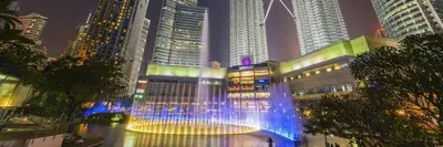 a fountain in the middle of a city at night at Avenue K in Kuala Lumpur