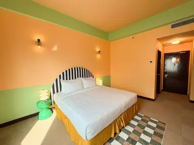 a bedroom with a bed with a striped headboard at The Très Hotel in Kuala Lumpur