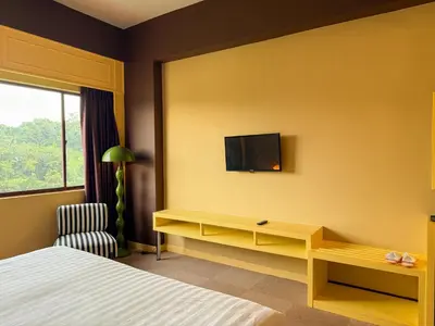 a hotel room with a bed and a tv on the wall at The Très Hotel in Kuala Lumpur