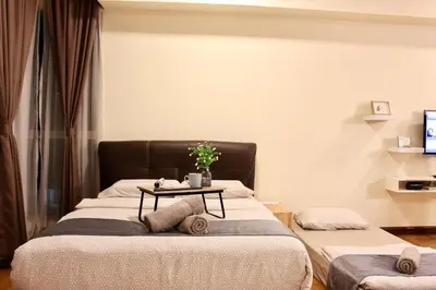 two beds in a room with a table on the bed at ✦Time & Traveller✦Regalia Suites and Residence✦KLCC view Infinity Pool✦双子塔无边泳池 in Kuala Lumpur
