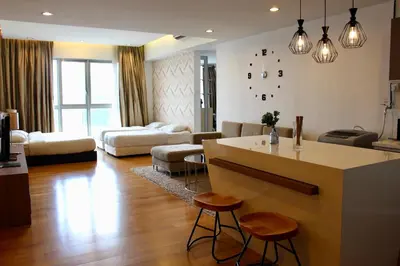 a kitchen and living room with a counter and stools at ✦Time & Traveller✦Regalia Suites and Residence✦KLCC view Infinity Pool✦双子塔无边泳池 in Kuala Lumpur