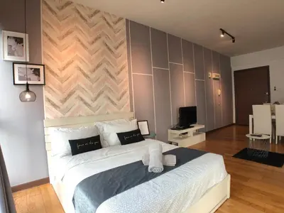 a bedroom with a large white bed and a wall at ✦Time & Traveller✦Regalia Suites and Residence✦KLCC view Infinity Pool✦双子塔无边泳池 in Kuala Lumpur