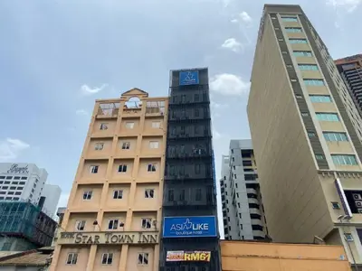 a tall building with a clock on top of it at Asia Like Boutique Hotel in Kuala Lumpur
