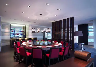 a dining room with a round table and red chairs at Grand Hyatt Kuala Lumpur in Kuala Lumpur