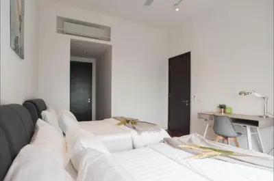two white beds in a room with a desk at KLCC The Mews Home in Kuala Lumpur