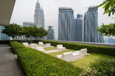 a garden with white chairs and a city skyline at KLCC The Mews Home in Kuala Lumpur