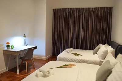 a hotel room with two beds and a desk at KLCC The Mews Home in Kuala Lumpur