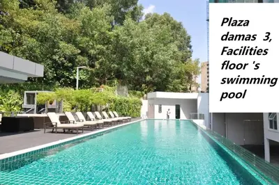 a swimming pool with chaises and chairs next to a building at Corporate hotel suites at hartamas / mont kiara in Kuala Lumpur