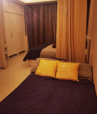 a bedroom with two beds and two yellow pillows at Corporate hotel suites at hartamas / mont kiara in Kuala Lumpur