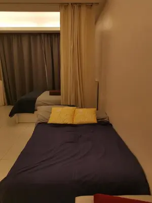 a bedroom with two beds with yellow pillows at Corporate hotel suites at hartamas / mont kiara in Kuala Lumpur