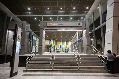 a woman standing in front of a building with stairs at Velocity KL By PSM Luxury Suites in Kuala Lumpur
