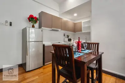 a kitchen with a wooden table and a refrigerator at Regalia Residence by FANTASTIC in Kuala Lumpur
