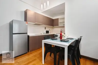 a kitchen with a table and chairs and a refrigerator at Regalia Residence by FANTASTIC in Kuala Lumpur