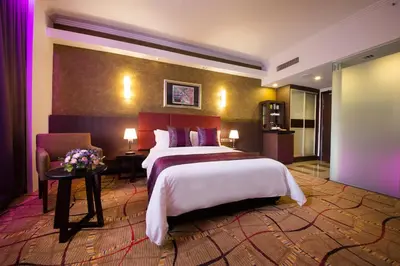 a hotel room with a large bed and a chair at AnCasa Hotel Kuala Lumpur, Chinatown in Kuala Lumpur