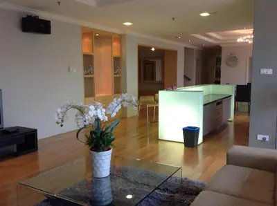 a living room with a vase of flowers on a glass table at Times Service Suites @ Times Square in Kuala Lumpur