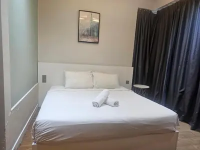 a bedroom with a bed with two pillows on it at Anggun Residences Serviced Suites in Kuala Lumpur