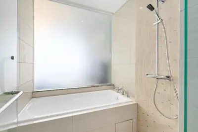 a bathroom with a white tub and a shower at Anggun Residences Serviced Suites in Kuala Lumpur