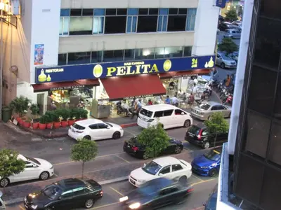 a city street with cars parked in front of a building at Safari Hotel in Kuala Lumpur