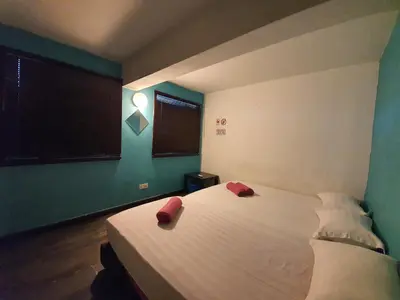 a bedroom with a bed with two red pillows on it at Travel Hub Guesthouse in Kuala Lumpur