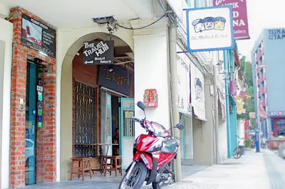 a red scooter parked in front of a building at Travel Hub Guesthouse in Kuala Lumpur