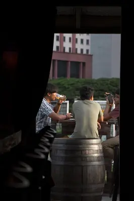 a group of people sitting around a barrel at Travel Hub Guesthouse in Kuala Lumpur
