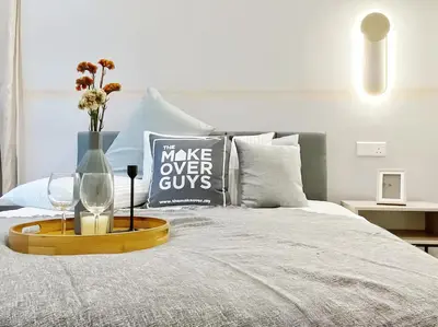 a bed with a tray with a vase and two glasses at The Robertson Bukit Bintang in Kuala Lumpur