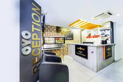 a restaurant with a bar with black leather chairs at Hotel O Kl Centre Point in Kuala Lumpur
