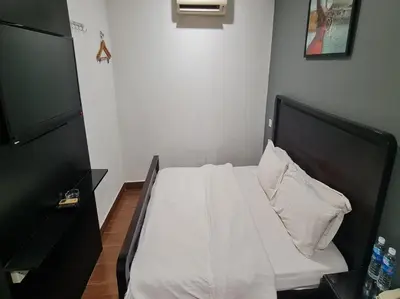 a bed with white sheets and a black headboard at Hotel O Crossroads Hotel in Kuala Lumpur