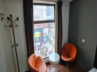 a room with two chairs and a large window at Hotel O Crossroads Hotel in Kuala Lumpur