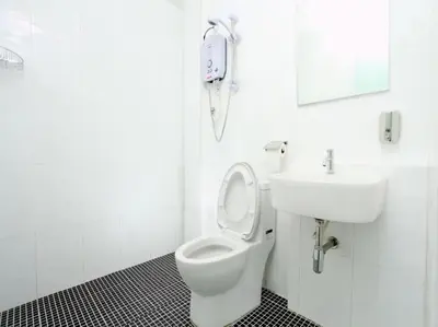 a white bathroom with a toilet and a sink at Hotel O Crossroads Hotel in Kuala Lumpur