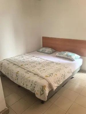 a bed with a blanket and pillows on it at Sha La La Hostel in Kuala Lumpur