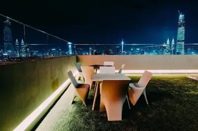 a table and chairs on a rooftop at night at Velocity Residence in Kuala Lumpur