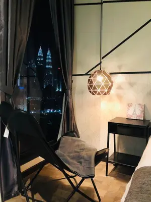 a chair in a room with a desk and a window at Expressionz Suites near KLCC, IJN by Wodages in Kuala Lumpur