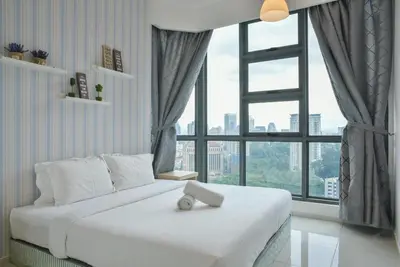 a white bed in a room with a large window at The Robertson Bukit Bintang by Wowhome in Kuala Lumpur