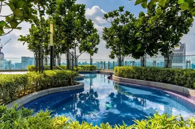 a swimming pool with trees and bushes at The Robertson Bukit Bintang by Wowhome in Kuala Lumpur