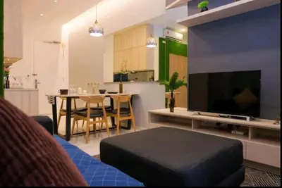 a living room with a table and a large screen television at The Robertson Bukit Bintang by Wowhome in Kuala Lumpur