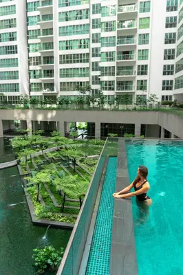 a woman sitting in a swimming pool in a building at Regalia Upper View Hotel in Kuala Lumpur