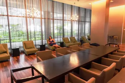 a woman sitting in a room with a table and chairs at Regalia Upper View Hotel in Kuala Lumpur