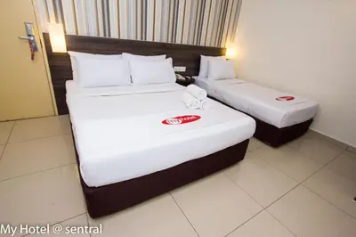 two beds in a hotel room with white sheets at My Hotel @ Sentral in Kuala Lumpur
