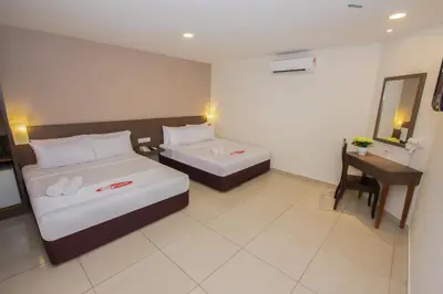 a hotel room with two beds and a desk at My Hotel @ Sentral in Kuala Lumpur