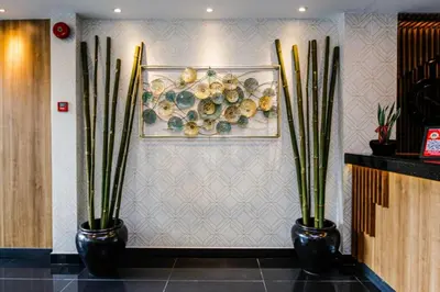 two black vases with plants on a wall at My Hotel @ KL Sentral in Kuala Lumpur