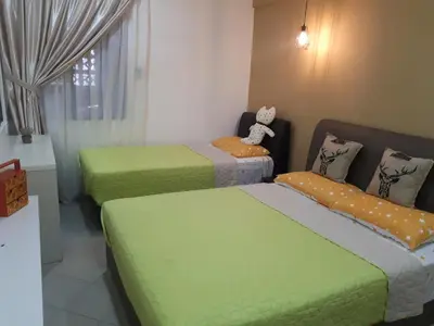 a room with two beds with green sheets at The FORUM condominium, Jalan Inai, Off Jalan Tun Razak in Kuala Lumpur