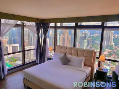 a bedroom with a bed and a large window at The Apartments at Times Square KL by Robinsons in Kuala Lumpur