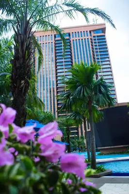 a resort with palm trees and a hotel at The Apartments at Times Square KL by Robinsons in Kuala Lumpur