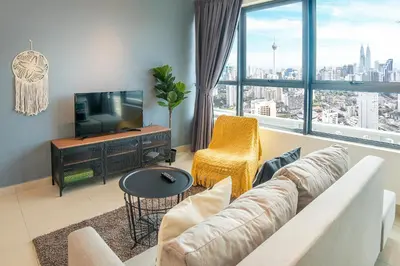 a living room with a couch and a television at Arte Plus by Cobnb KLCC in Kuala Lumpur