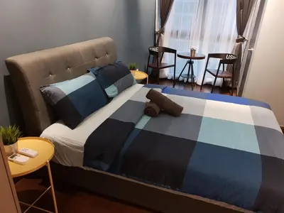 a bed with a blue and black blanket on it at Sunway Velocity V Residence Suites in Kuala Lumpur