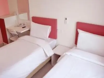 two beds in a small room with a desk and a bed at YY318 Hotel Bukit Bintang in Kuala Lumpur
